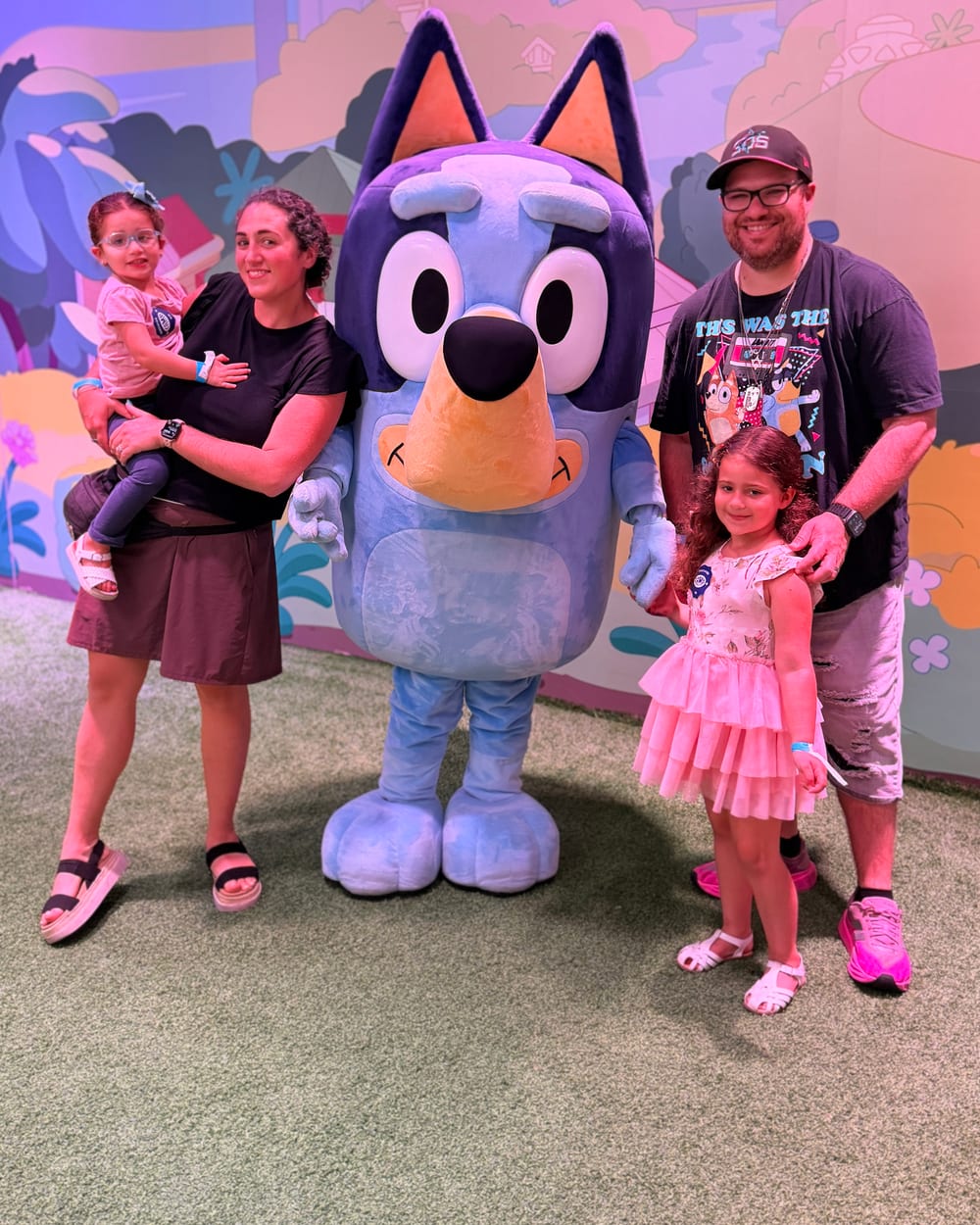 AJ with his wife and two daughters at a Bluey character meet and greet.